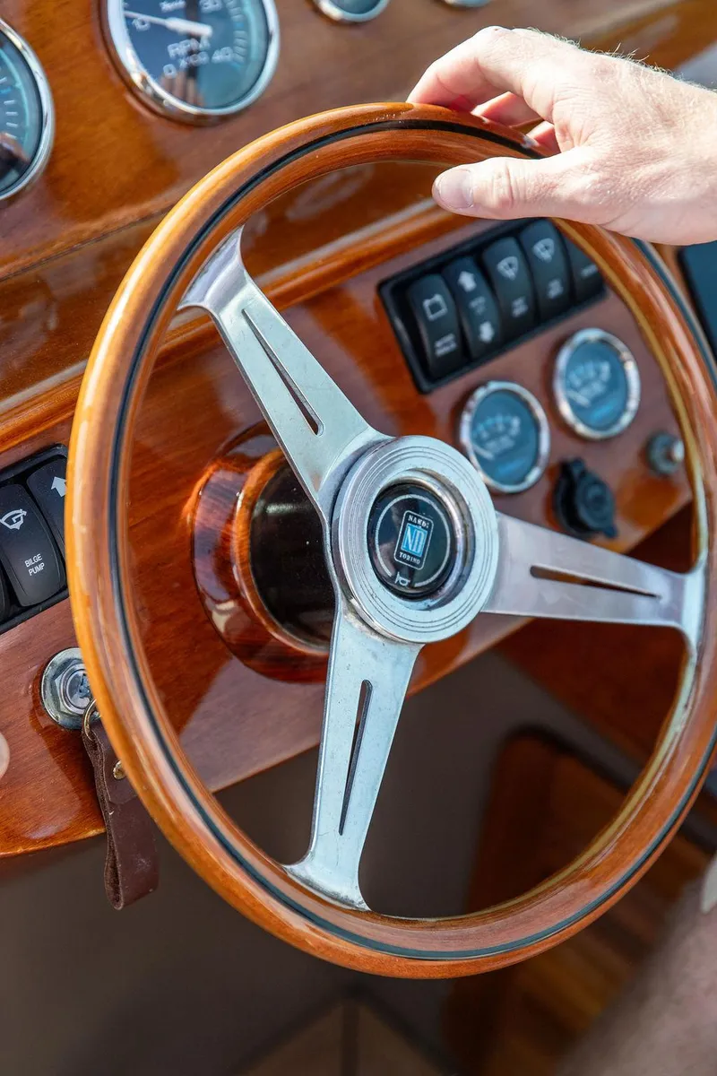 Slide: The Image of Steering wheel of a 2003 Hinckley Talaria 29R boat with wooden dashboard. - 31