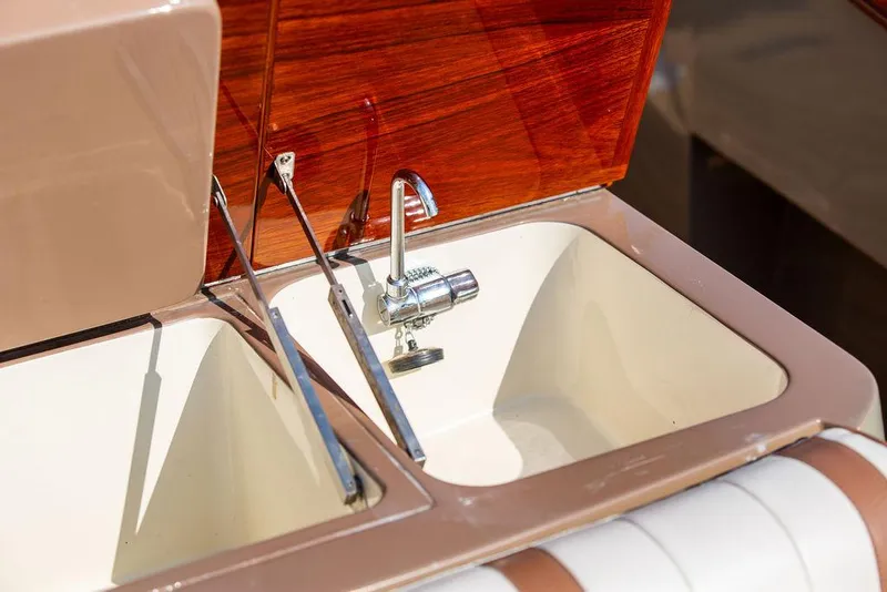 Slide: The Image of 2003 Hinckley Talaria 29R boat sink with chrome faucet and wooden paneling. - 39