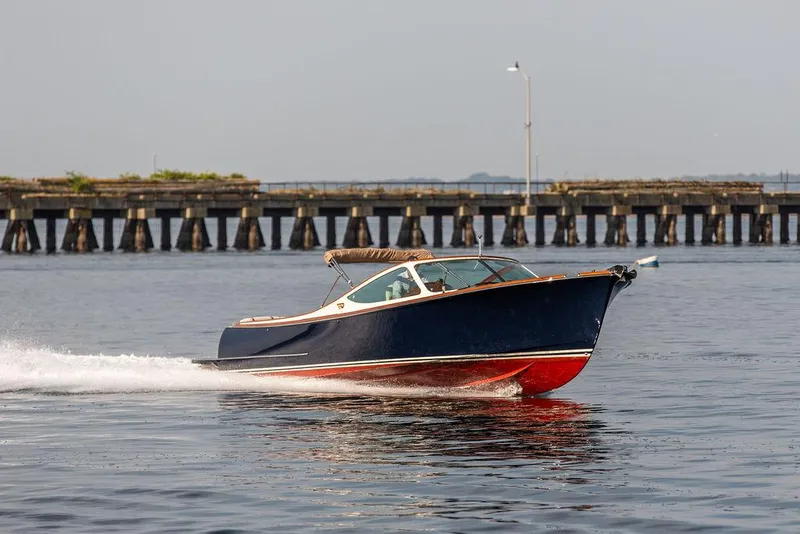 Slide: The Image of 2003 Hinckley Talaria 29R cruising on water near a pier. - 6