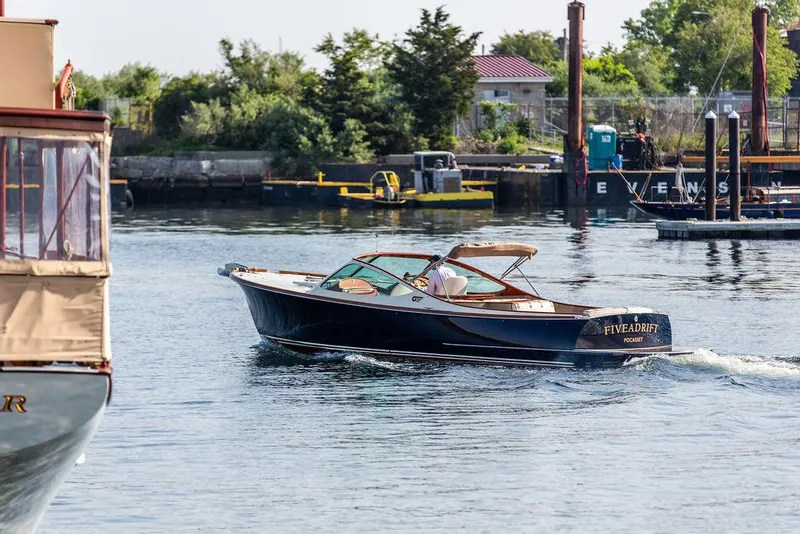 Slide: The Image of 2003 Hinckley Talaria 29R cruising in a scenic harbor setting. - 8