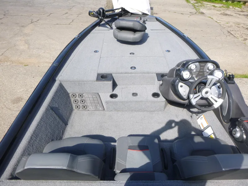 Slide: The Image of 2023 Tracker Pro Team 195 TXW Tournament Edition boat interior with steering console and seating. - 4