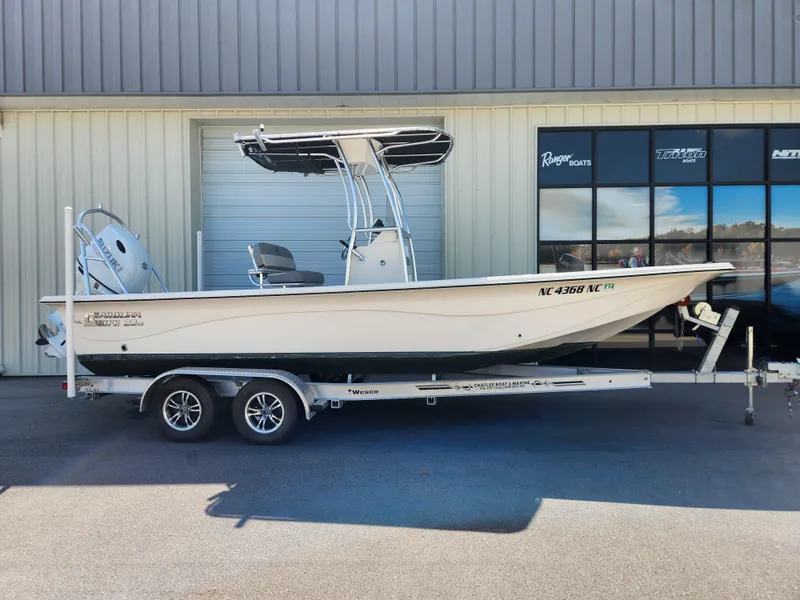 The Image of 2024 Carolina Skiff 23 LS boat on trailer, parked outside a building. - 0