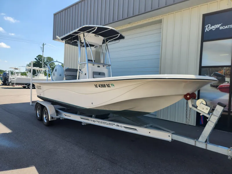 Slide: The Image of 2024 Carolina Skiff 23 LS boat on trailer outside a marine dealership. - 1