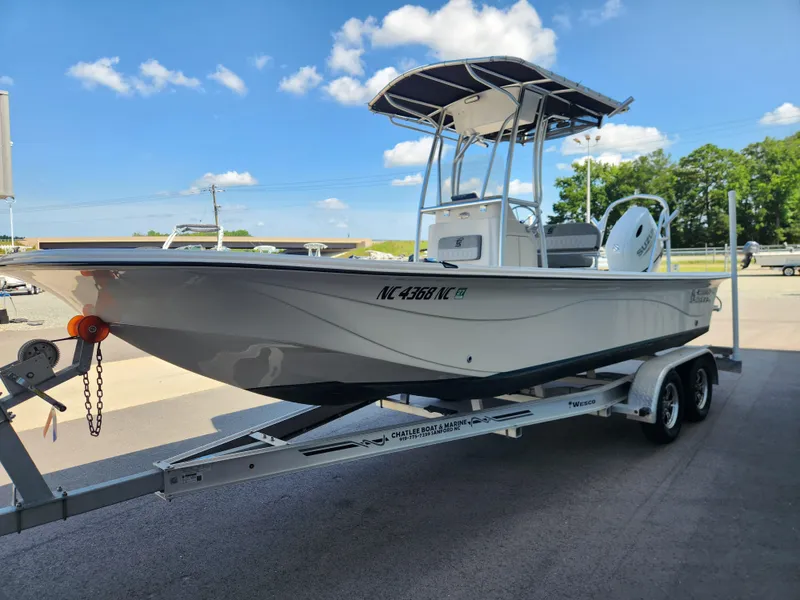 Slide: The Image of 2024 Carolina Skiff 23 LS boat on trailer under clear blue sky. - 5