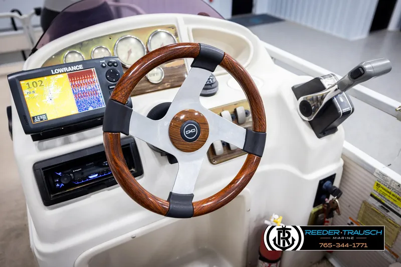 Slide: The Image of Steering console of 2007 Premier 2223 Navigator boat with Lowrance display and wooden wheel. - 30