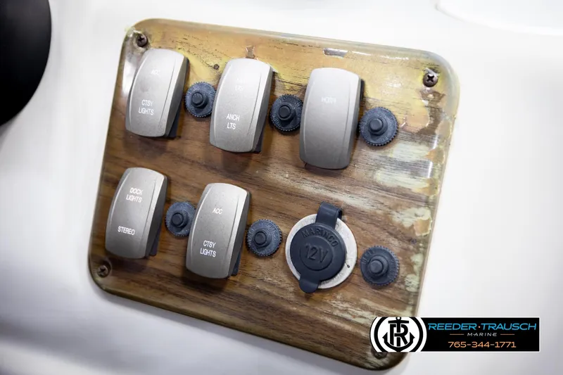 Slide: The Image of Control panel of a 2007 Premier 2223 Navigator boat with labeled switches and 12V outlet. - 37