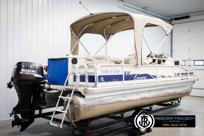 Slide: The Image of 2007 Premier 2223 Navigator pontoon boat with Suzuki outboard motor in a garage setting. - 6