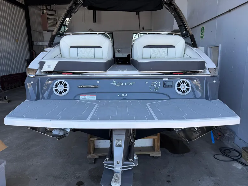Slide: The Image of 2020 Regal LS4 Surf boat in a garage, showcasing rear seating and swim platform. - 5