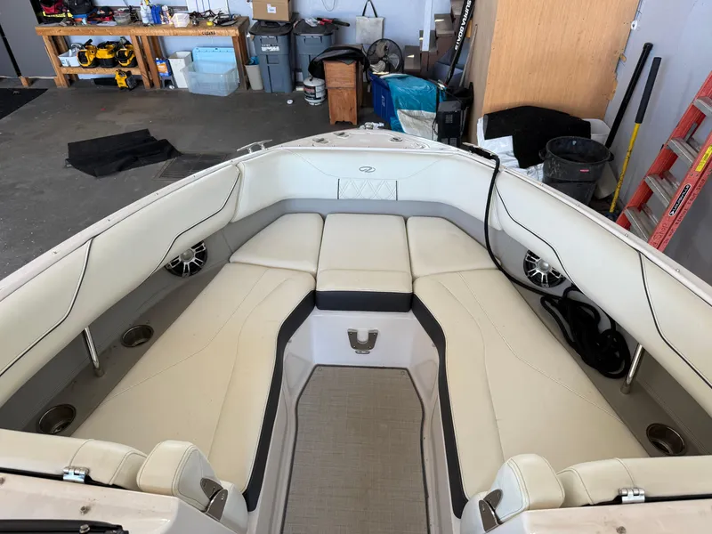 Slide: The Image of 2020 Regal LS4 Surf boat interior with white seating and speakers in a garage. - 9