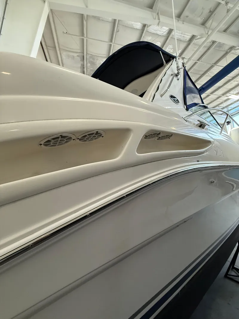 Slide: The Image of 2001 Sea Ray 340 Sundancer boat in a showroom, showcasing sleek design and detailing. - 3