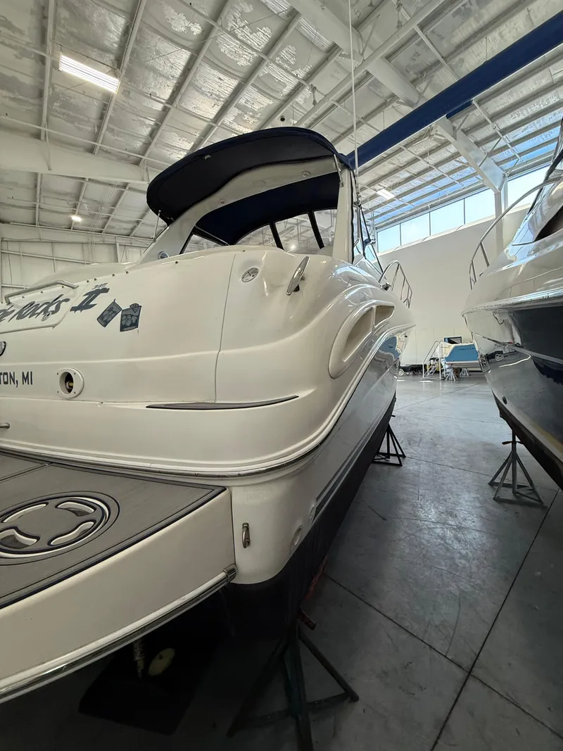 Slide: The Image of 2001 Sea Ray 340 Sundancer yacht in indoor storage, showcasing sleek design and white exterior. - 4