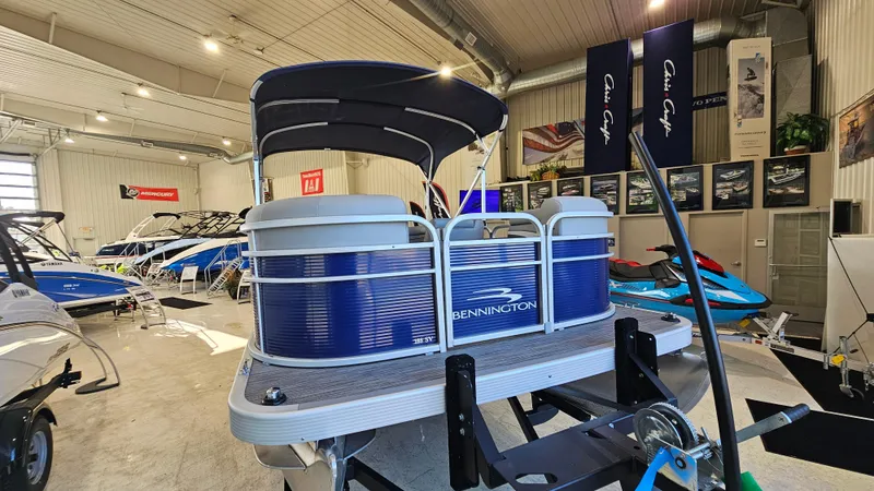 Slide: The Image of 2020 Bennington 188 SV pontoon boat displayed in a showroom with other watercraft. - 6
