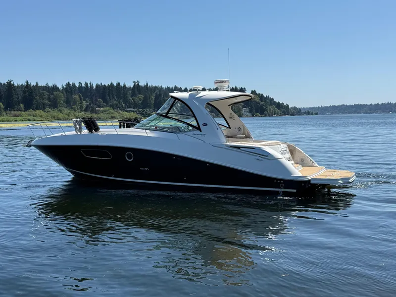 Slide: The Image of 2012 Sea Ray 370 Sundancer yacht cruising on a serene lake under clear blue skies. - 1