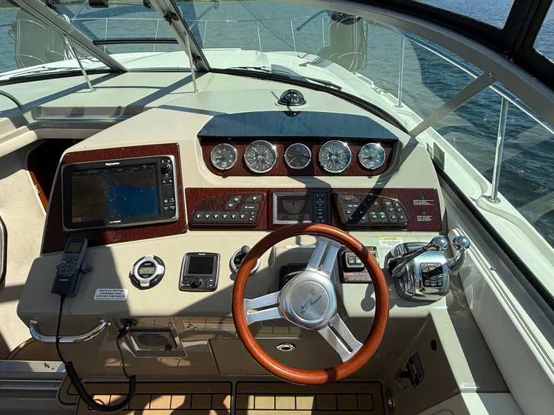 Slide: The Image of Cockpit of 2012 Sea Ray 370 Sundancer with steering wheel, navigation system, and control panel. - 14