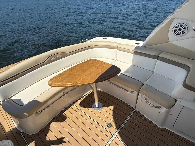 Slide: The Image of Luxurious seating area on 2012 Sea Ray 370 Sundancer yacht with wooden table, overlooking water. - 22