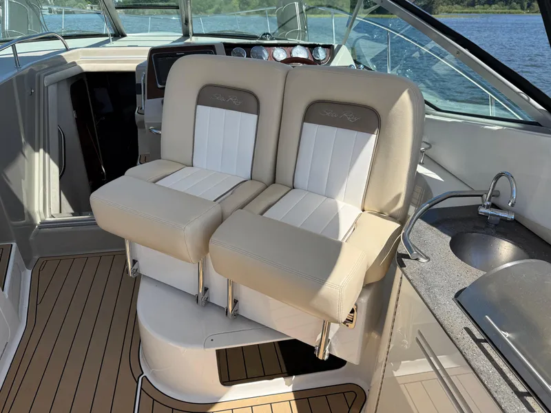 Slide: The Image of 2012 Sea Ray 370 Sundancer cockpit with beige seating and compact kitchenette. - 23