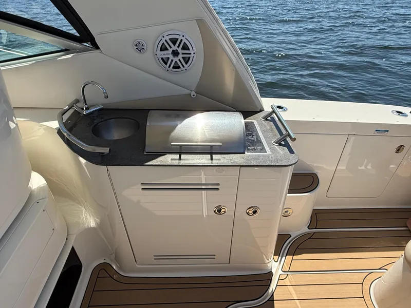 Slide: The Image of Outdoor kitchenette on 2012 Sea Ray 370 Sundancer yacht with sink and grill, overlooking water. - 26