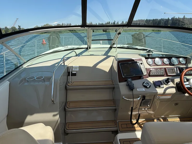 Slide: The Image of 2012 Sea Ray 370 Sundancer helm with navigation instruments and scenic water view. - 35