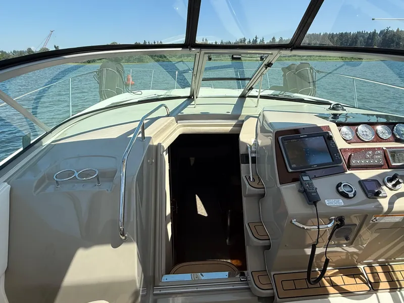 Slide: The Image of Cockpit view of 2012 Sea Ray 370 Sundancer, featuring navigation controls and open cabin entrance. - 36