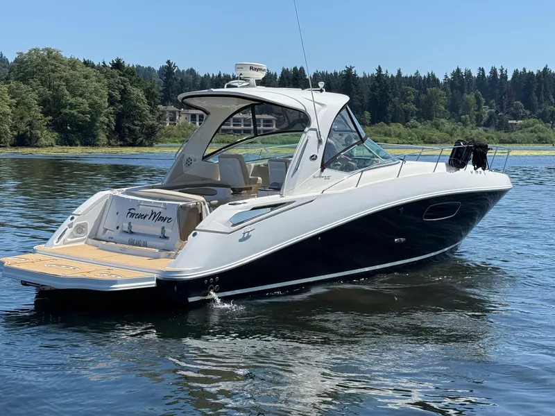 Slide: The Image of 2012 Sea Ray 370 Sundancer boat on a serene lake with forested background. - 4