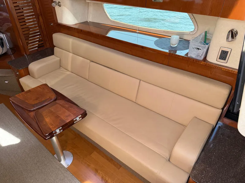 Slide: The Image of Luxurious interior of 2012 Sea Ray 370 Sundancer with beige leather seating and wooden accents. - 42