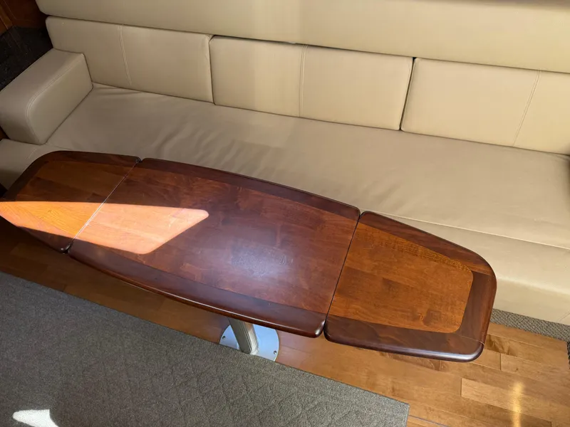 Slide: The Image of Interior of 2012 Sea Ray 370 Sundancer with wooden table and beige seating. - 44