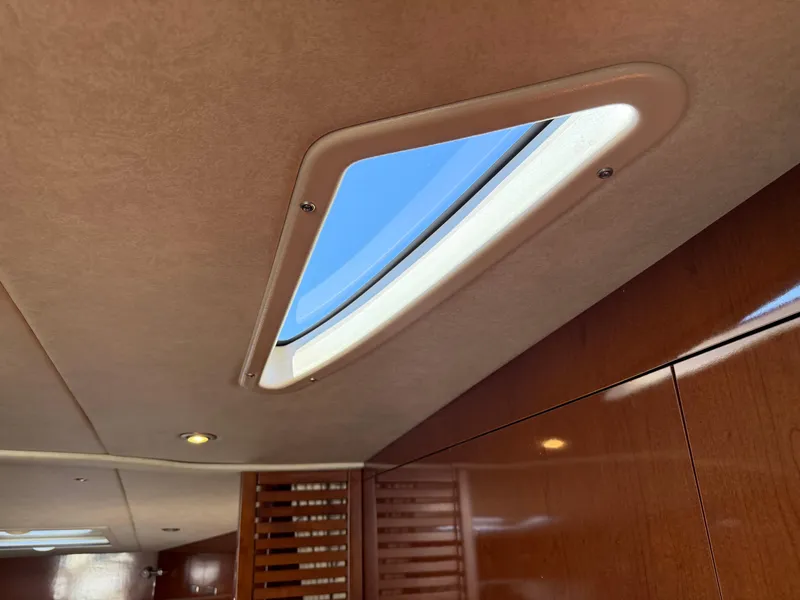 Slide: The Image of Interior view of 2012 Sea Ray 370 Sundancer with skylight and wooden paneling. - 46