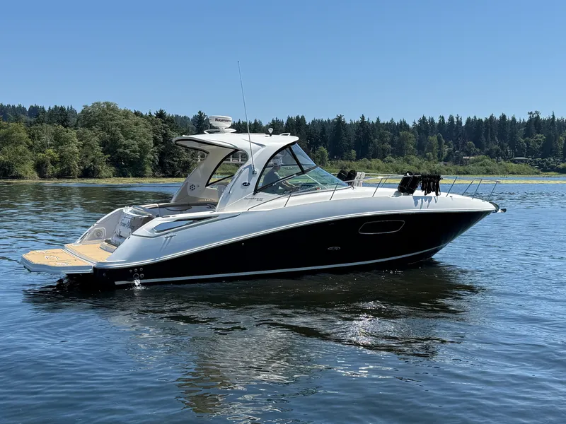 Slide: The Image of 2012 Sea Ray 370 Sundancer yacht on a serene lake with forested background. - 5