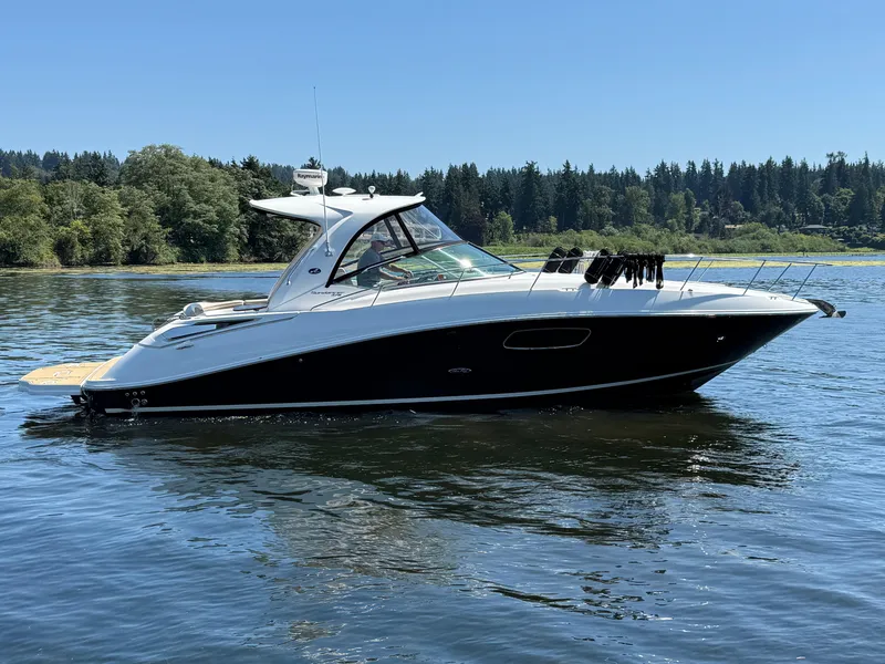 Slide: The Image of 2012 Sea Ray 370 Sundancer yacht on a serene lake with forested background. - 6