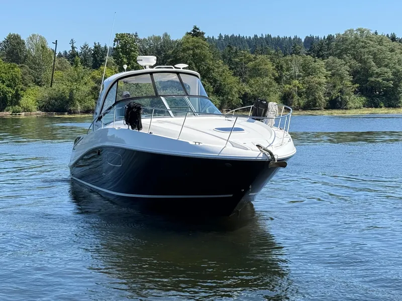 Slide: The Image of 2012 Sea Ray 370 Sundancer yacht cruising on a serene lake with lush forest backdrop. - 8