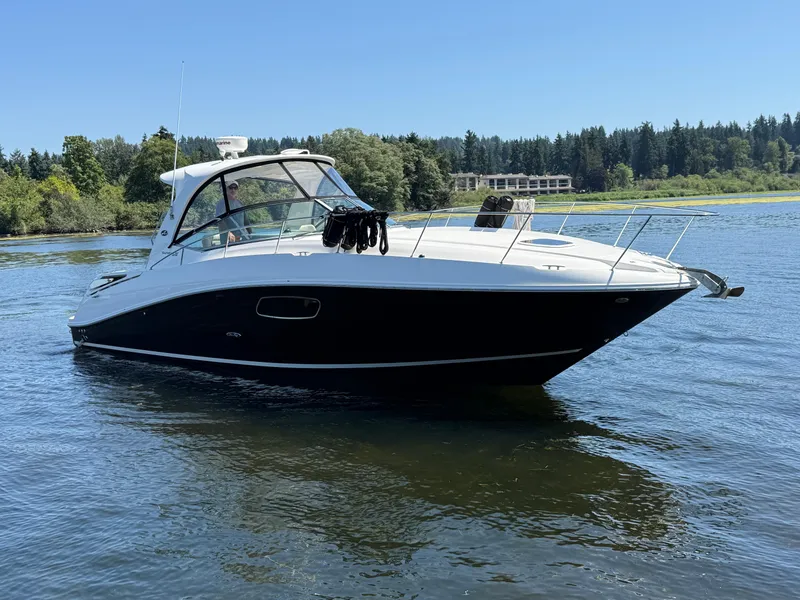 Slide: The Image of 2012 Sea Ray 370 Sundancer cruising on a serene lake with forested shoreline. - 9