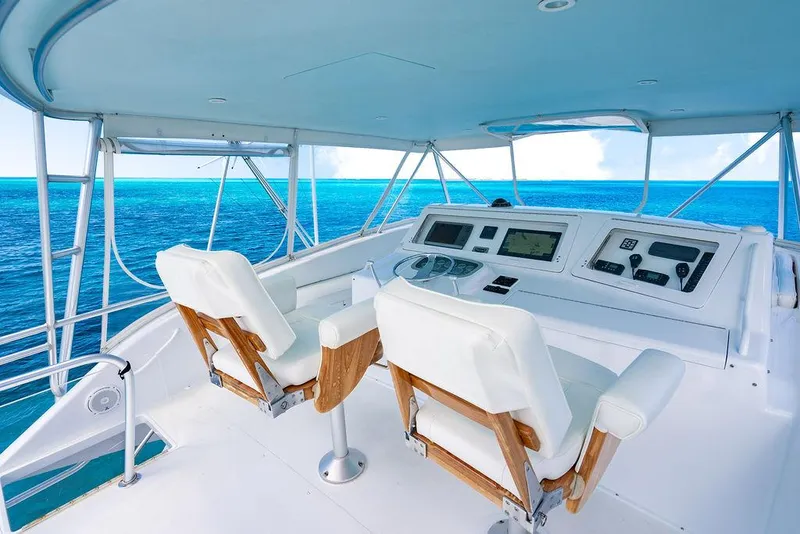 Slide: The Image of 1999 Viking Convertible yacht helm with ocean view, featuring white seats and navigation controls. - 13