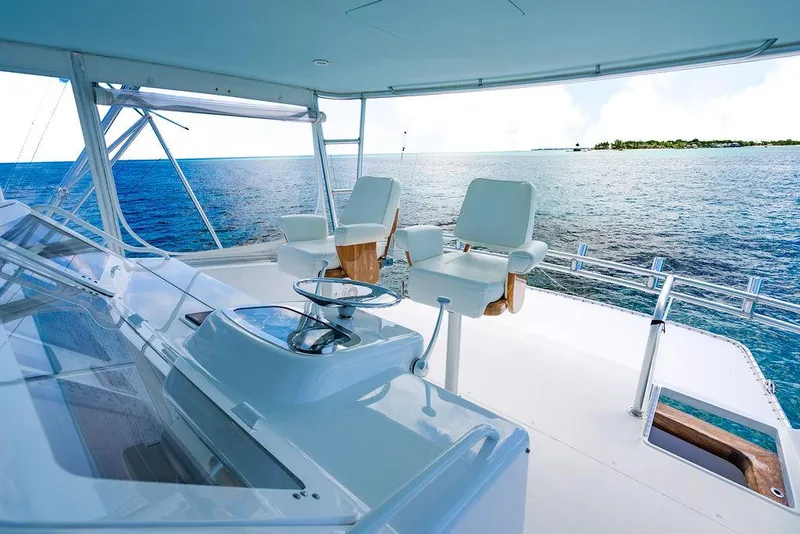 Slide: The Image of 1999 Viking Convertible yacht helm with ocean view and white captain chairs. - 15