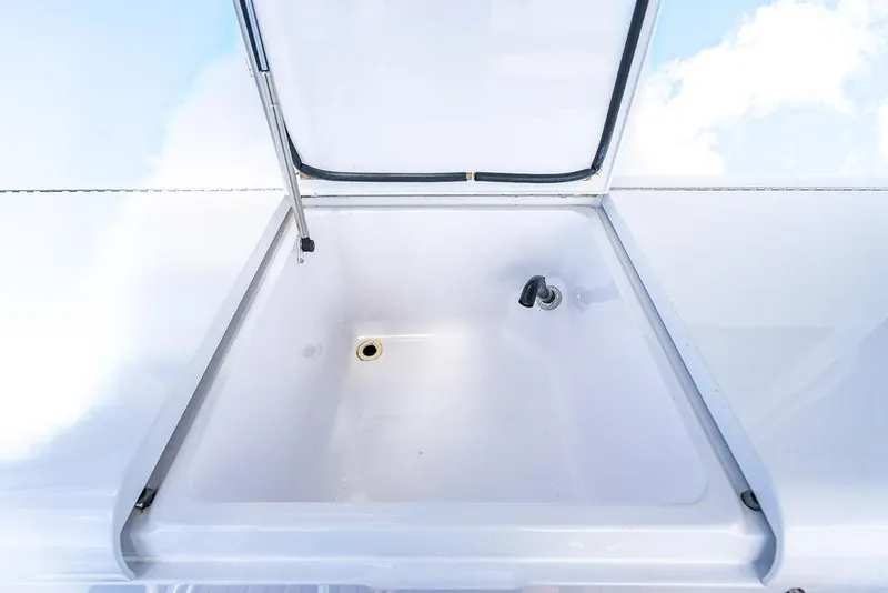 Slide: The Image of Open storage compartment on 1999 Viking Convertible boat, featuring a clean white interior. - 20