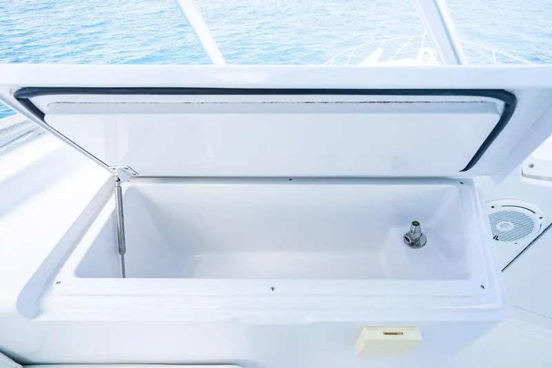 Slide: The Image of Open storage compartment on 1999 Viking Convertible boat with ocean view. - 21