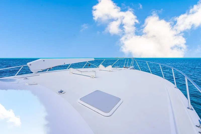 Slide: The Image of Bow view of 1999 Viking Convertible yacht on open sea under blue sky. - 25