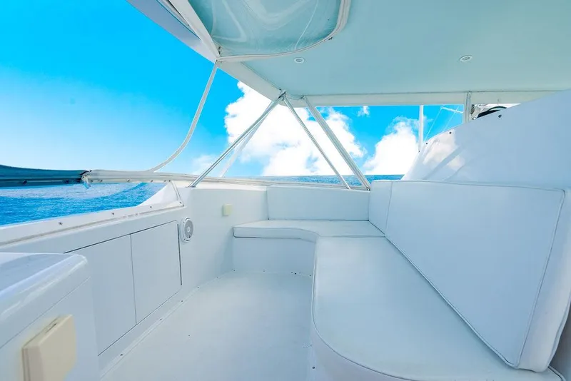 Slide: The Image of 1999 Viking Convertible boat interior with white seating, ocean view, and blue sky. - 28