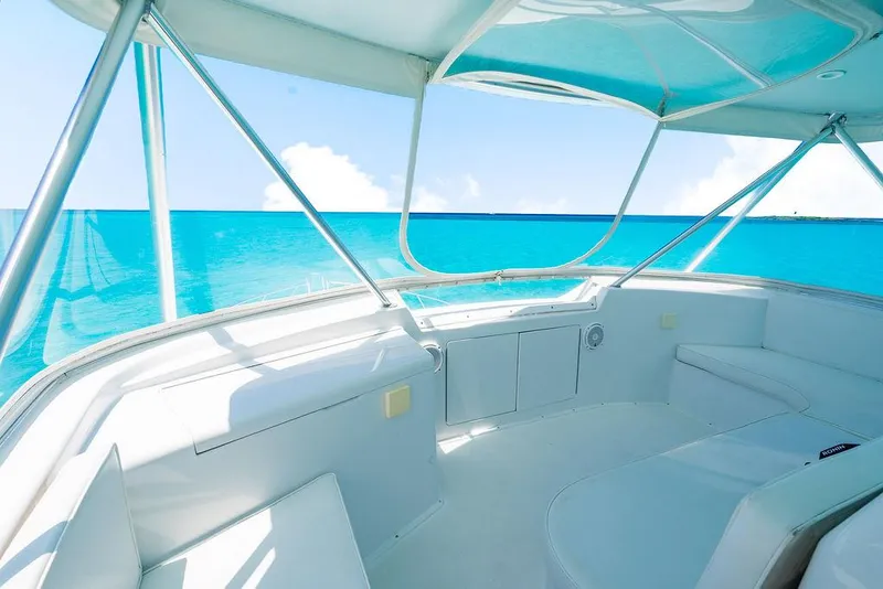 Slide: The Image of 1999 Viking Convertible yacht interior with ocean view, featuring sleek white seating and clear blue waters. - 34