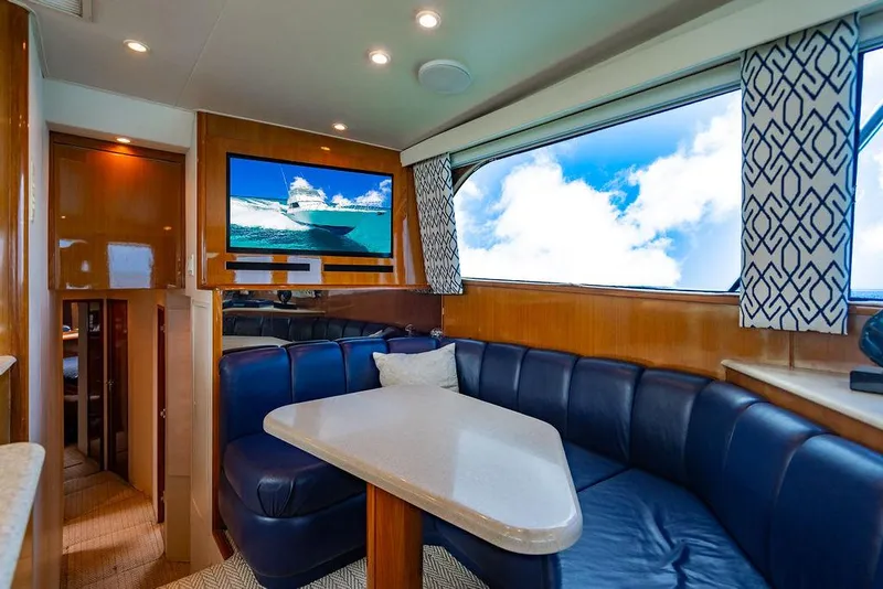 Slide: The Image of Luxurious interior of a 1999 Viking Convertible yacht with blue seating and scenic window view. - 44