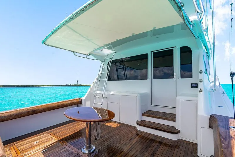 Slide: The Image of 1999 Viking Convertible yacht deck with wooden flooring, table, and ocean view. - 6