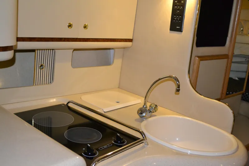 Slide: The Image of 1998 Sea Ray 330 Sundancer kitchen with stove, sink, and modern design. - 10