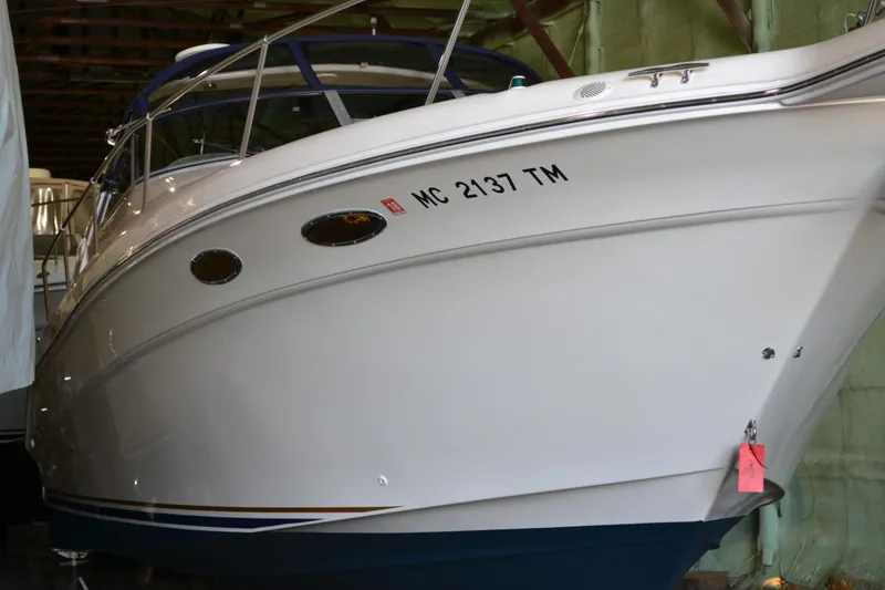 Slide: The Image of 1998 Sea Ray 330 Sundancer boat in storage, white hull with registration number. - 2