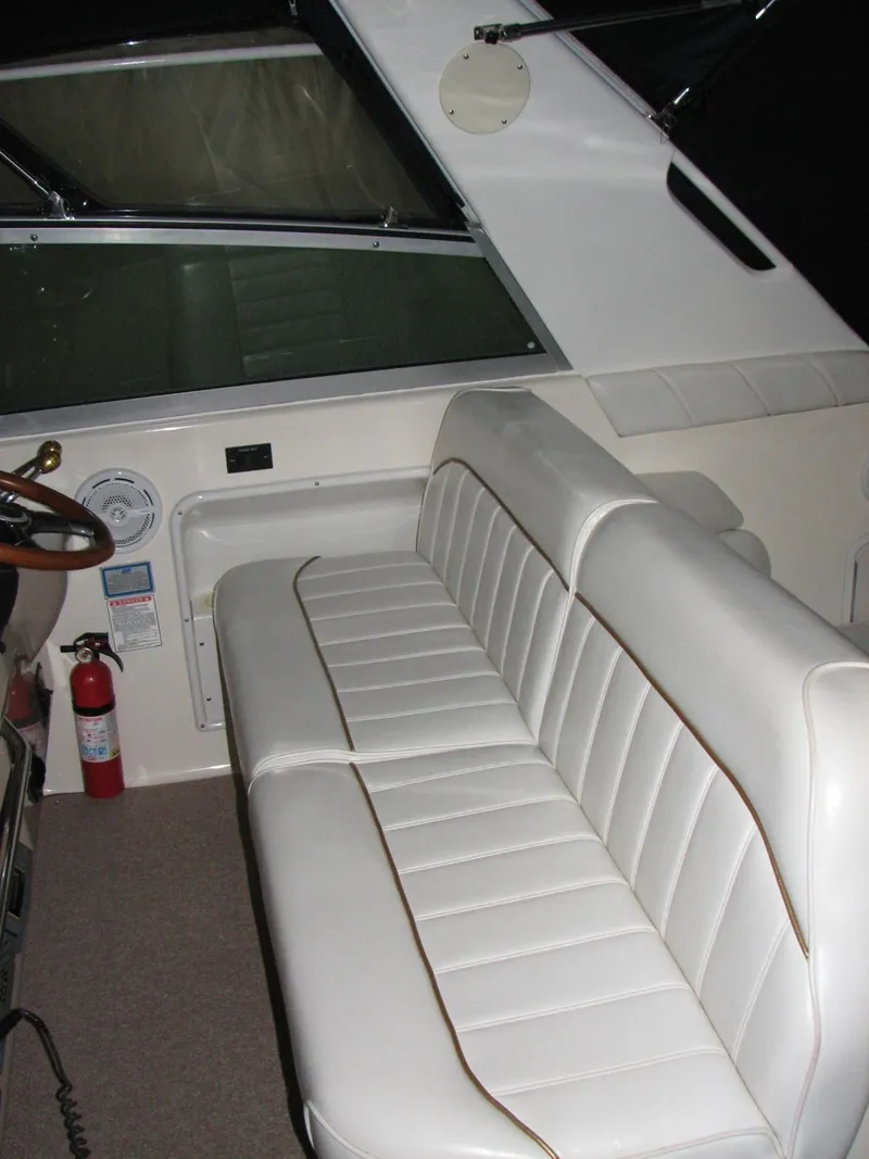Slide: The Image of 1998 Sea Ray 330 Sundancer interior with white seating and dashboard view. - 5