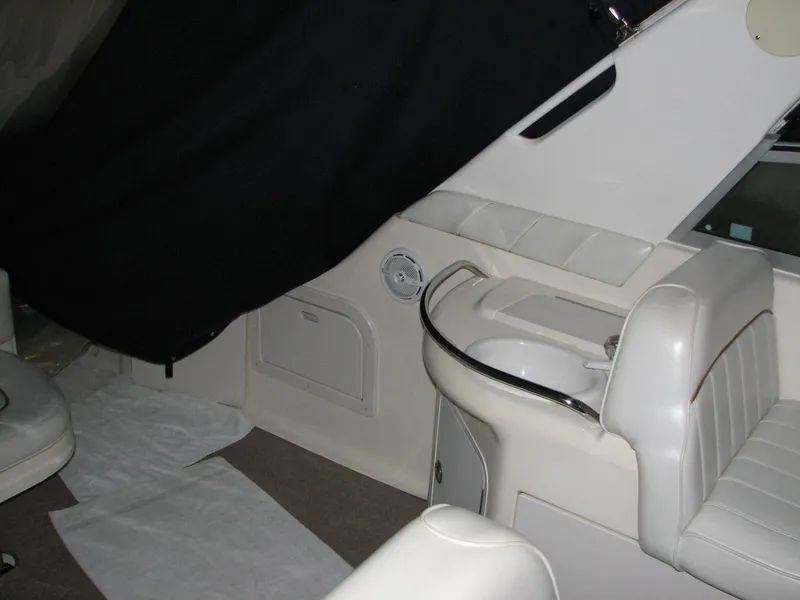 Slide: The Image of 1998 Sea Ray 330 Sundancer interior with white seating and compact sink area. - 8