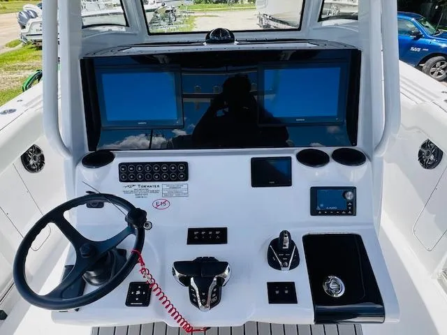 Slide: The Image of 2026 Tidewater 302 CC Adventure boat dashboard with steering wheel and electronic controls. - 4