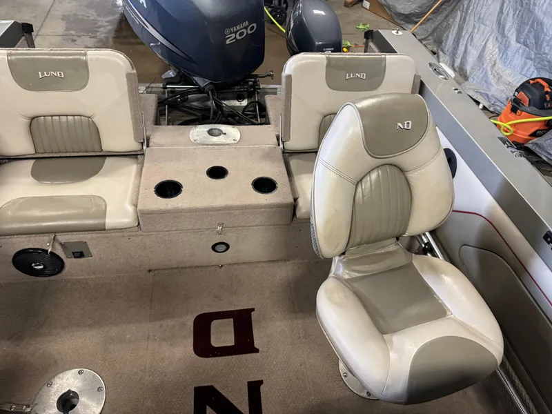 Slide: The Image of 2002 Lund 1850 Tyee Gran Sport boat interior with Yamaha 200 engine, featuring beige seating. - 7