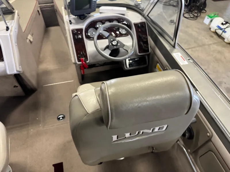 Slide: The Image of 2002 Lund 1850 Tyee Gran Sport boat interior with steering wheel and dashboard. - 9