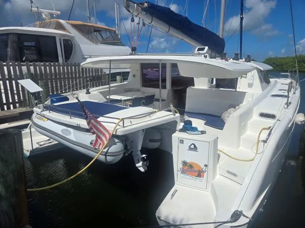 Slide: The Image of 2008 Fountaine Pajot Salina 48 catamaran docked, featuring spacious deck and American flag. - 35