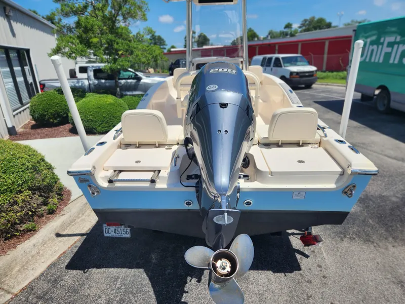 Slide: The Image of 2015 Grady-White 191 Coastal Explorer boat with powerful outboard motor, parked outdoors. - 3