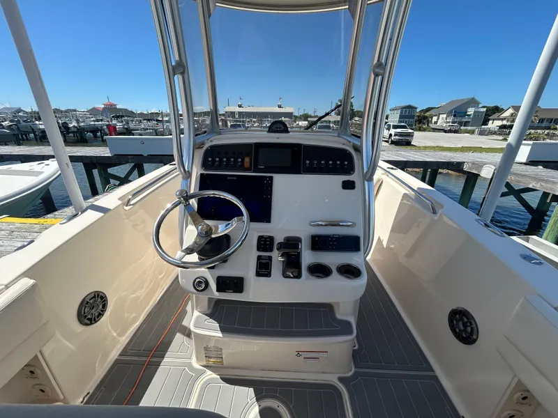 Slide: The Image of 2019 Grady-White Fisherman 236 boat console with steering wheel and controls at marina. - 10